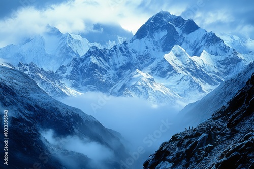 A stunning view of a snow-capped mountain range with a layer of clouds covering the valley below. photo