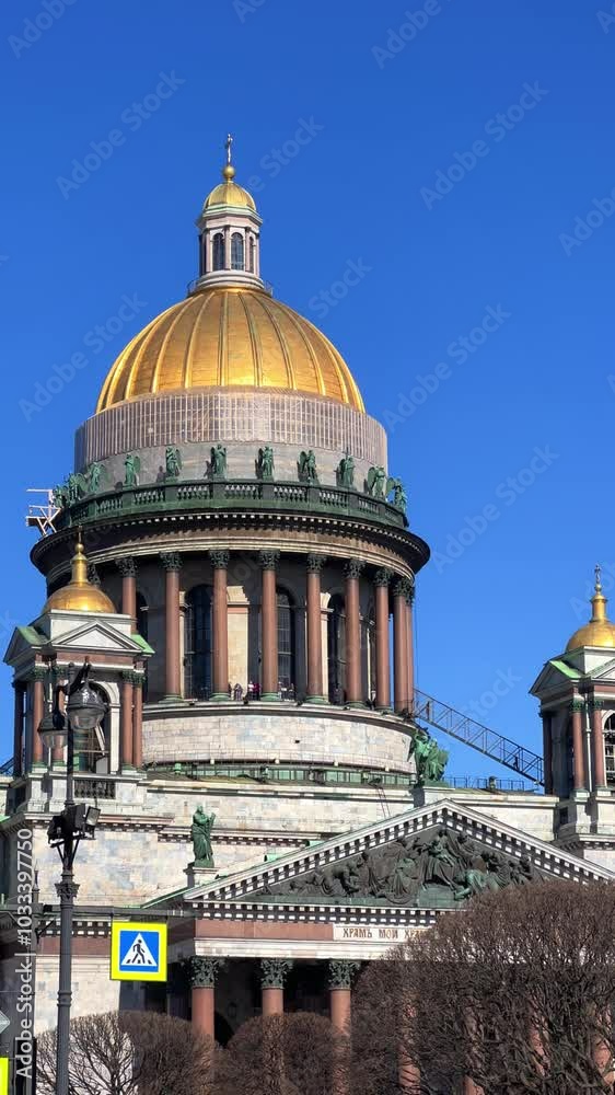 St. Isaac's Cathedral, Russia. Spring view of St. Petersburg, the cultural center of the city. Sunlit views of the sculptures of angels on the colonnade of St. Peter's Cathedral. St. Isaac's Cathedral St. Isaac's Cathedral, Russia. Spring view of St. Petersburg, the cultural center of the city. Sunlit views of the sculptures of angels on the colonnade of St. Peter's Cathedral. St. Isaac's Cathedral