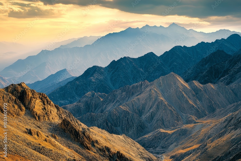 Dramatic mountain range at sunset with layered peaks and blue hues. Dramatic mountain range at sunset with layered peaks and blue hues.