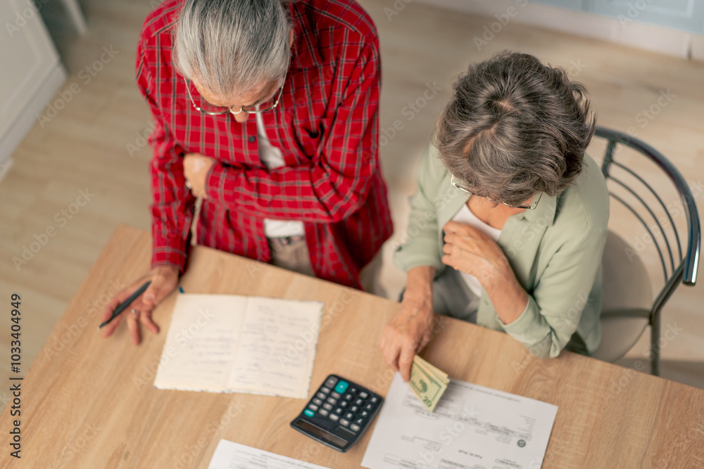 top shot in bright kitchen an elderly couple at the table count their expenses monthly payment summing up the results of the year utilities count monthly survival count money bad mood top shot in bright kitchen an elderly couple at the table count their expenses monthly payment summing up the results of the year utilities count monthly survival count money bad mood