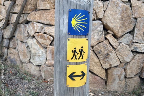 Camino de Santiago Hiking Trail Markers with Stone Wall Background photo