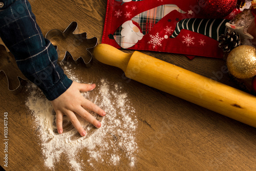 Child hand plying in flour. Making Christmas cookies photo