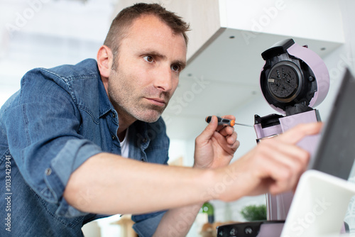 serious man repairing broken coffee machine