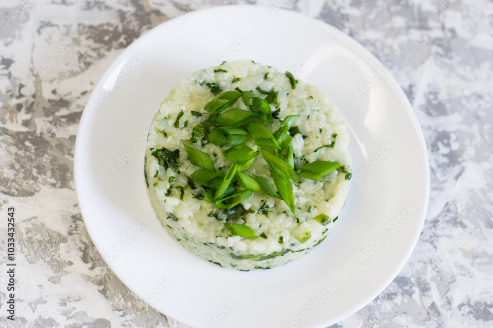 Vegan, vegetarian delicious dish. Rice with spinach on a white plate Vegan, vegetarian delicious dish. Rice with spinach on a white plate