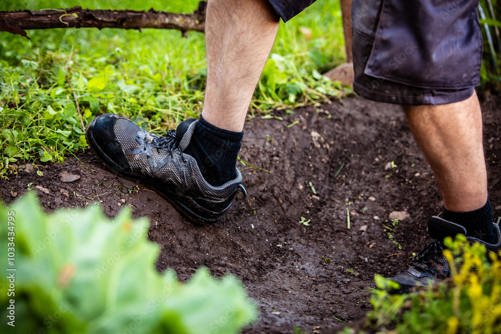 a man digs a hole and compacts the earth a man digs a hole and compacts the earth