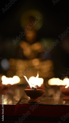 Lighting many candles in temples, religion, prayers and the concept of God. Close-up view of a burning flame on a candle isolated on black background.