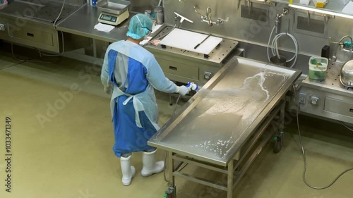 시신 안치실의 부검대를 청소하는 사람