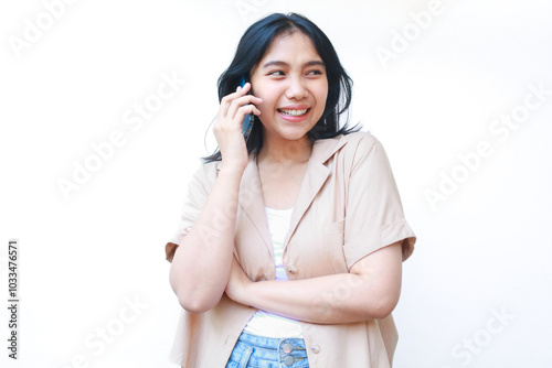 excited asian woman enjoy talking on mobile phone with laugh wearing casual brown shirt isolated on white background