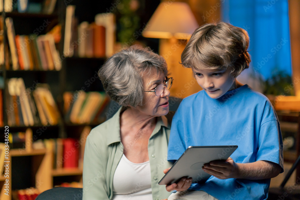 a warm light of living room with library big blue armchair elderly woman sitting with grandson watching news from tablet modern grandmother a warm light of living room with library big blue armchair elderly woman sitting with grandson watching news from tablet modern grandmother