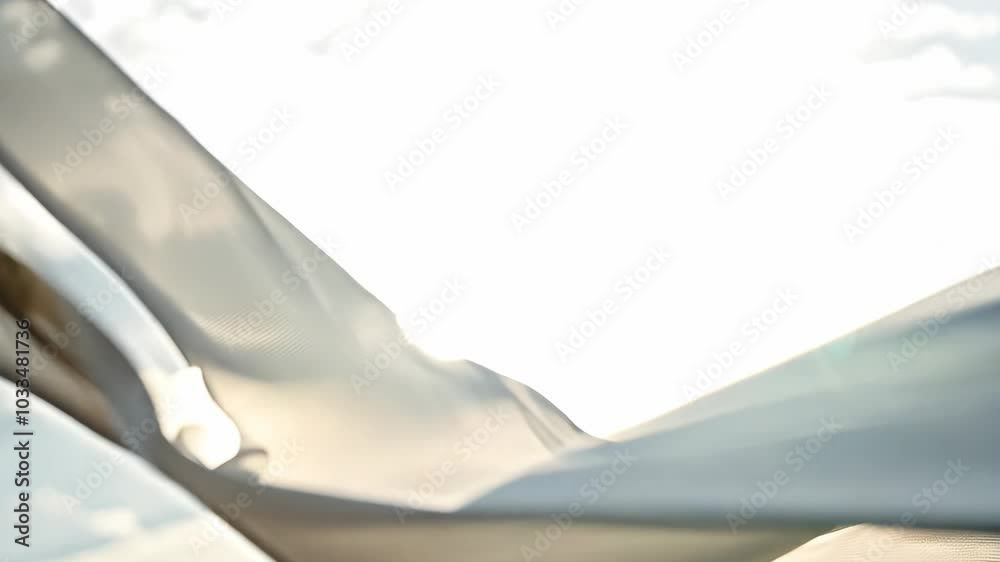 Elegant fabric dancing in the breeze under a sunny sky at a coastal location in the early afternoon Elegant fabric dancing in the breeze under a sunny sky at a coastal location in the early afternoon