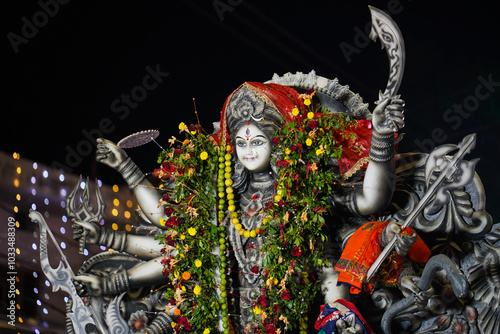 Vibrant Durga Statue with Floral Garland, Beautifully Adorned Durga for Navratri, Decorated Durga Idol at Night Stock Photo.
 photo