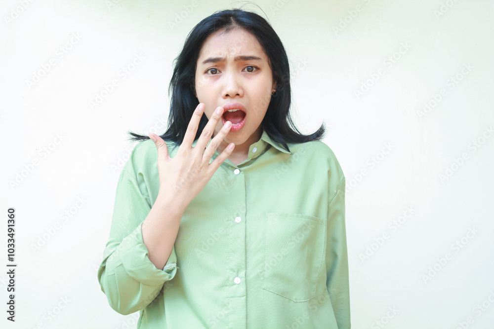 shocked dark hair asian woman looking at camera with open mouth showing wow expression and covering with hands wearing green oversized shirt isolated on white background shocked dark hair asian woman looking at camera with open mouth showing wow expression and covering with hands wearing green oversized shirt isolated on white background