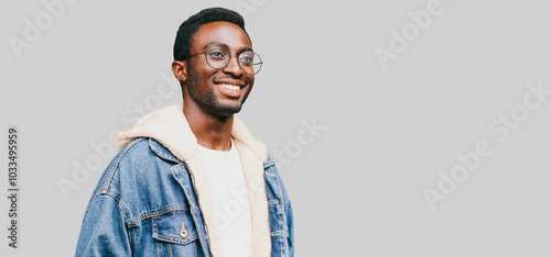 Portrait happy modern smiling young african man in glasses looking away isolated on gray background