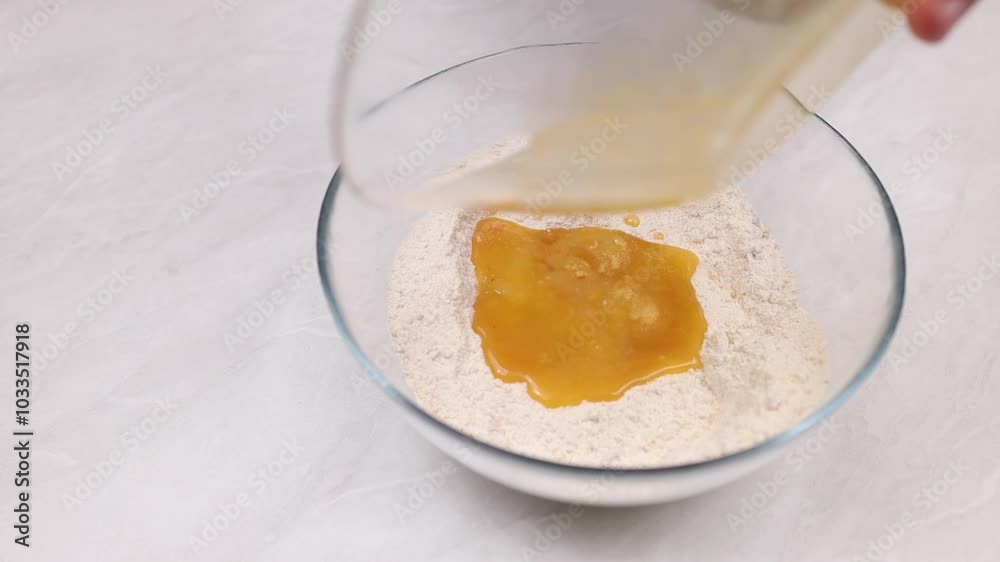 Mixing flour with mashed egggs in a glass bowl. Preparing the dough. Mixing flour with mashed egggs in a glass bowl. Preparing the dough.