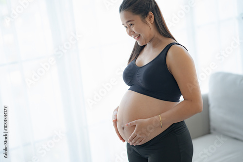 Pregnant asian woman holds hands on belly touching her baby caring about her health Beautiful happy pregnant woman tender mood photo of pregnancy. Free Download Pregnant asian woman holds hands on belly touching her baby caring about her health Beautiful happy pregnant woman tender mood photo of pregnancy. - GFXLoad