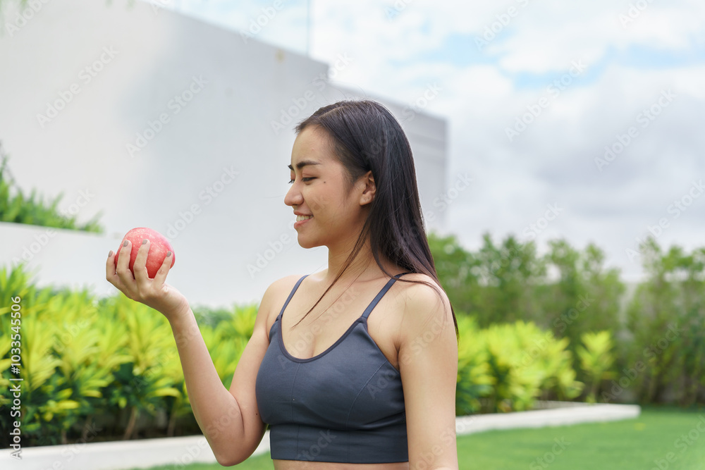 Fitness woman holding yoga mat with Fresh Apple Heathy clean vegan food before working out Beautiful confident asian woman practices in green park Fitness woman holding yoga mat with Fresh Apple Heathy clean vegan food before working out Beautiful confident asian woman practices in green park