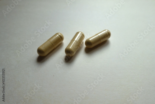 Macro of three beige capsules of Saccharomyces boulardii probiotic dietary supplement photo