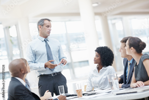 Businessman, presentation and discussion with employees in meeting for corporate plan or project at office. Man, executive or speaker talking to group or team for business growth or development