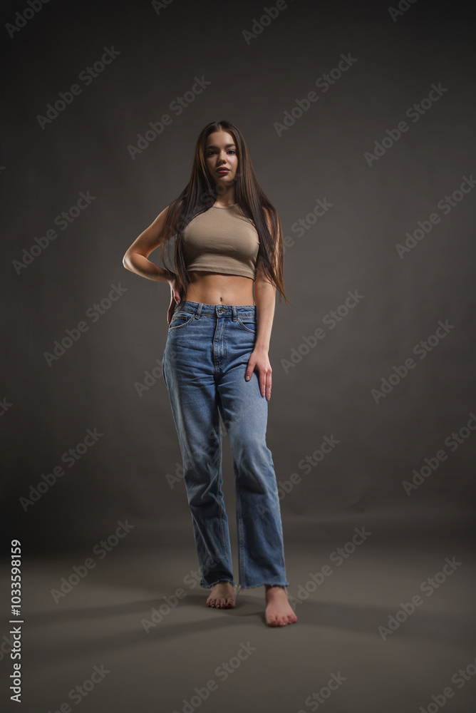 Beautiful girl posing on a gray background. Beauty and fashion. Beautiful girl posing on a gray background. Beauty and fashion.