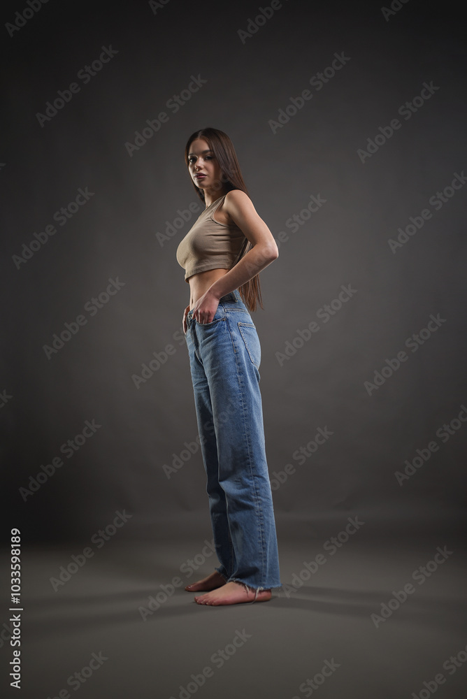 Beautiful girl posing on a gray background. Beauty and fashion.