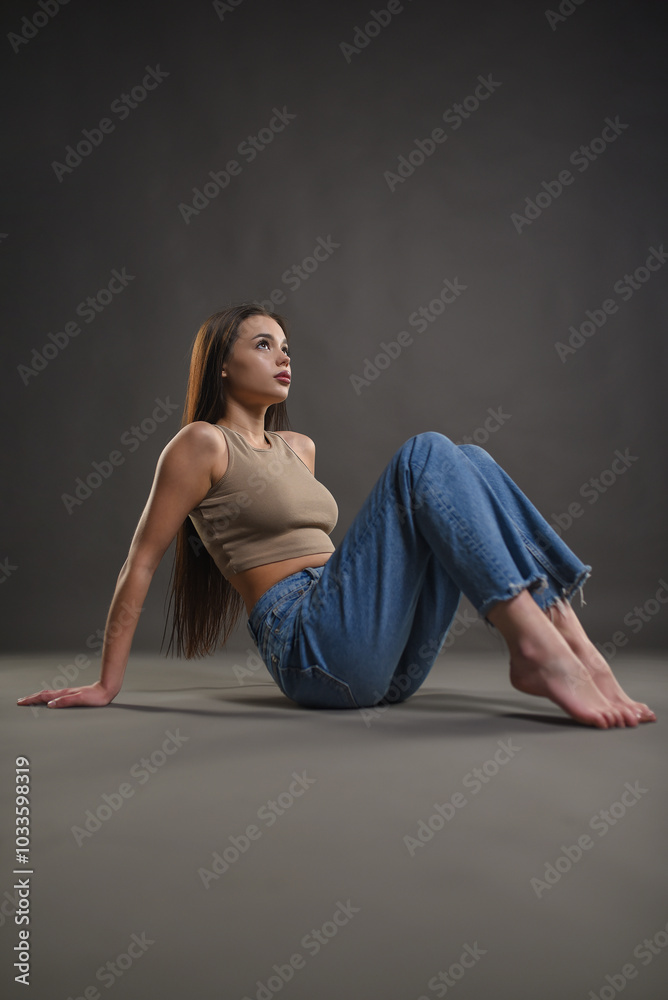 Beautiful girl posing on a gray background. Beauty and fashion. Beautiful girl posing on a gray background. Beauty and fashion.