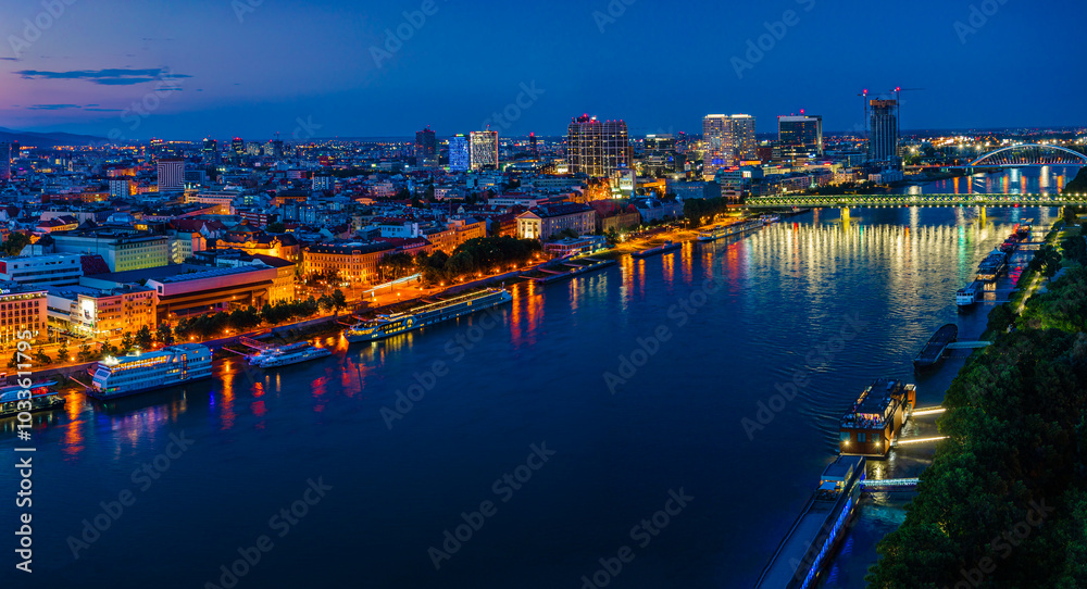 Obraz premium Bratislava, Slovakia - June 2022: City skyline on the shores of the Danube river; Bratislava castle, the old town, Eurovea; UFO bridge; SNP bridge; Appolo Bridge