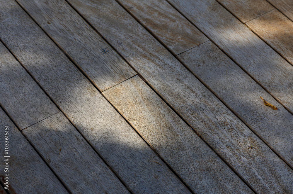 Sunlight dances on weathered wooden planks, revealing intricate textures and natural hues in a serene outdoor setting Sunlight dances on weathered wooden planks, revealing intricate textures and natural hues in a serene outdoor setting