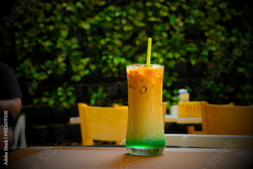 Closeup glass of coffee cocktail decorated with mint at bright bar counter background. Stir Ice Coffee with mint syrup in glass. Coffee with mint photo