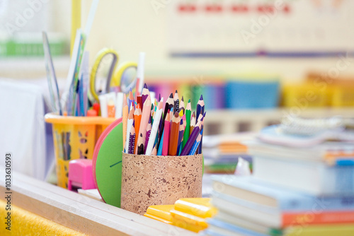 A close-up of a teacher s table featuring a pen holder and a storage. A close-up of a teacher s table featuring a sturdy pen holder filled with a variety of colorful pencils. The arrangement showcases
