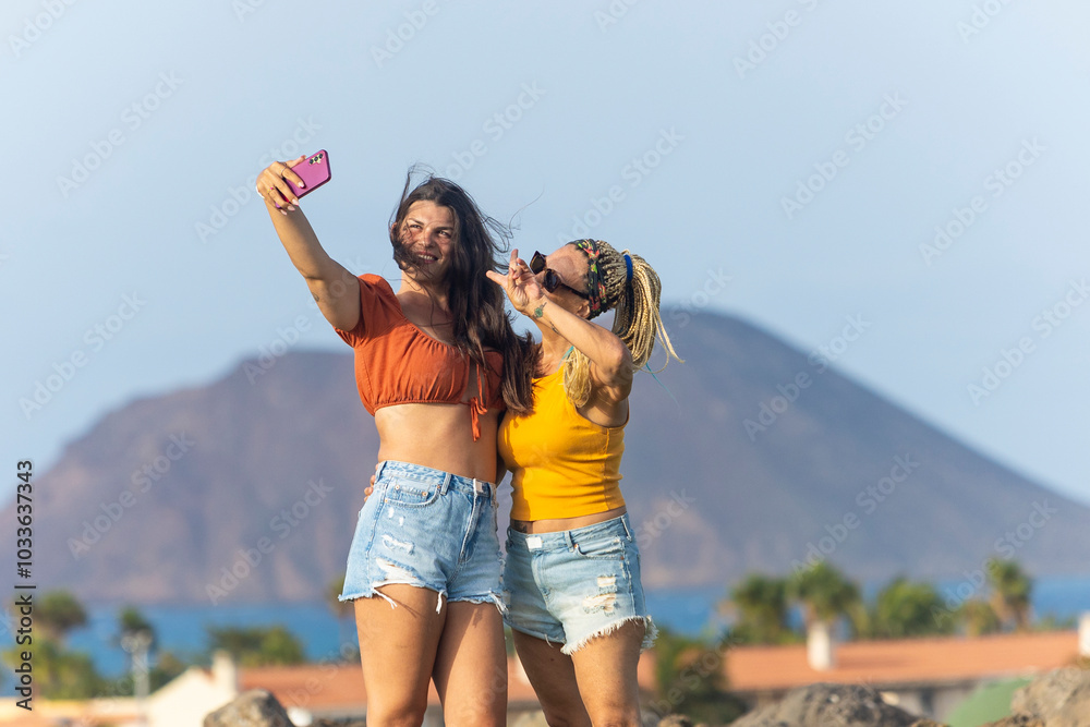Mother and transgender daughter taking selfie together outdoors Mother and transgender daughter taking selfie together outdoors