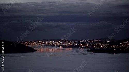 The suspension bridge from Bergen to Askoy at dusk with nice reflections in the water photo