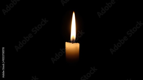 A burning candle with a bright flame on a black background with space for text. For themes related to memory, loss or spirituality, hope and keeping the fire of life burning.