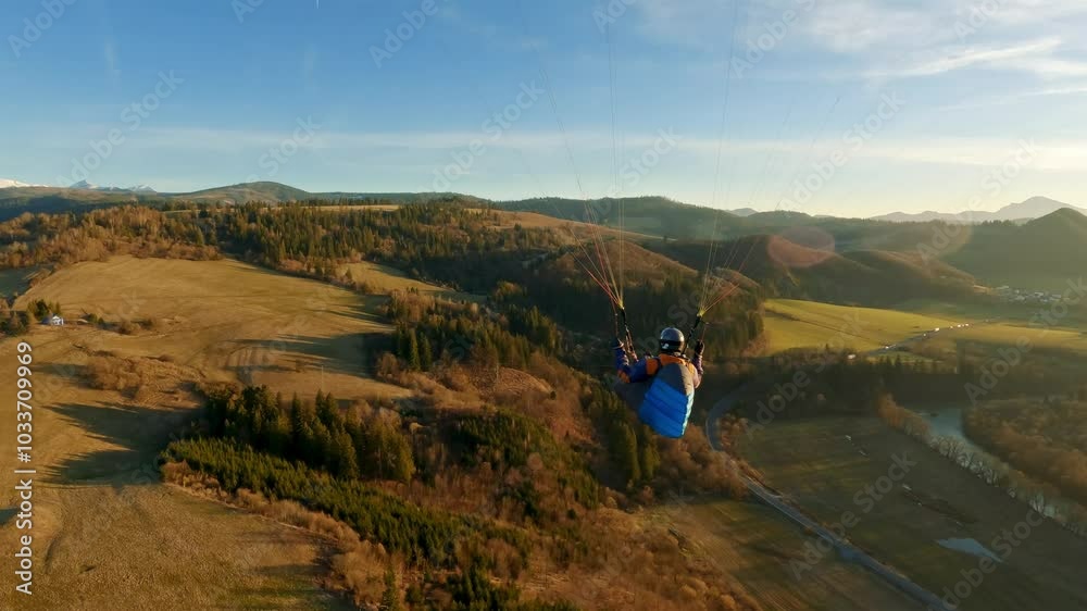 Paragliding flying freedom above autumn nature at golden sunrise Paragliding flying freedom above autumn nature at golden sunrise