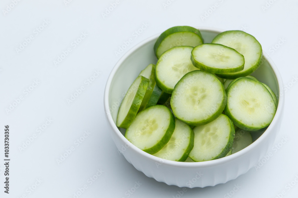 Slices of cucumber in ceramic bowl on white background Slices of cucumber in ceramic bowl on white background