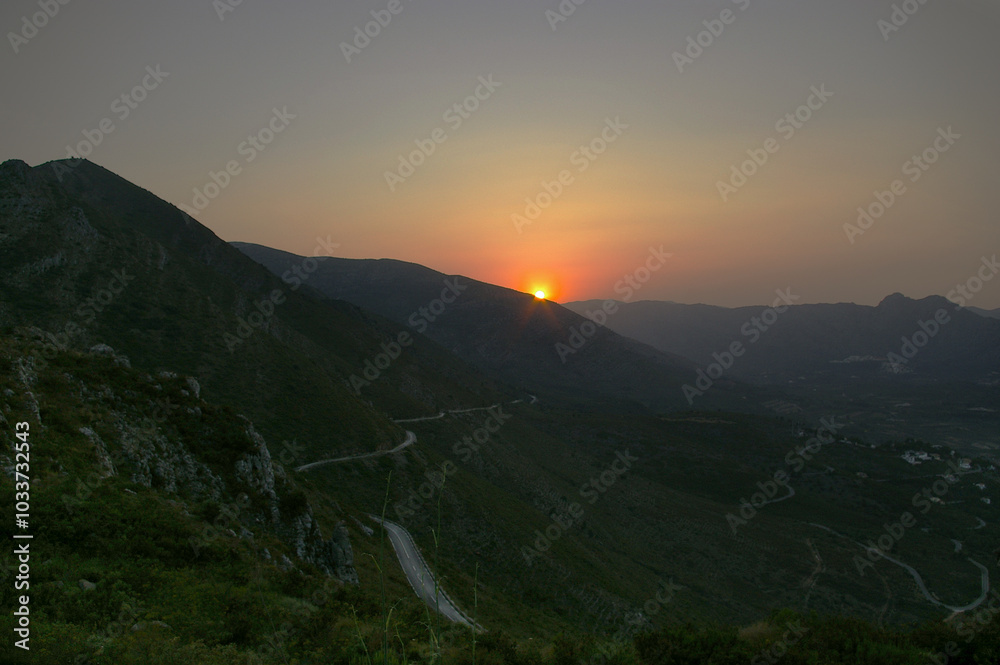 Fototapeta premium Paisaje natural con puesta de Sol desde la montaña Coll de Rates en la zona del pueblo de Parcent con vistas al valle. Alicante. España