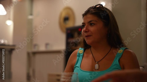 Young woman laughing with her friends dinning at a restaurant
