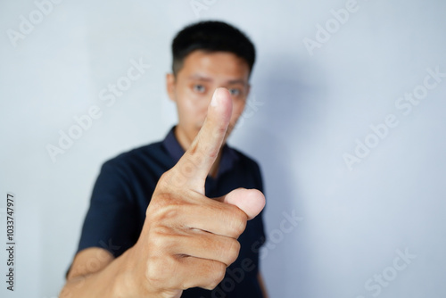 asian man giving forefinger close to camera