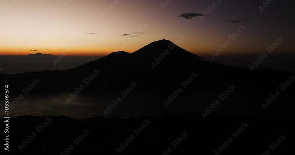 Pre-dawn silhouette of Mount Abang with soft light over Bali’s volcanic peaks in distance, serene silhouette of mountain against mysterious sky Pre-dawn silhouette of Mount Abang with soft light over Bali’s volcanic peaks in distance, serene silhouette of mountain against mysterious sky