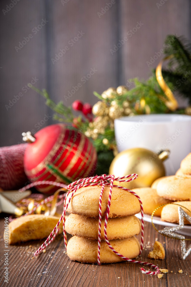 Stack and plate of tasty crumbly homemade shortbread sugar cookies, with Christmas decorations and fir tree, ready for holiday dinner, wooden cozy background copy space Stack and plate of tasty crumbly homemade shortbread sugar cookies, with Christmas decorations and fir tree, ready for holiday dinner, wooden cozy background copy space