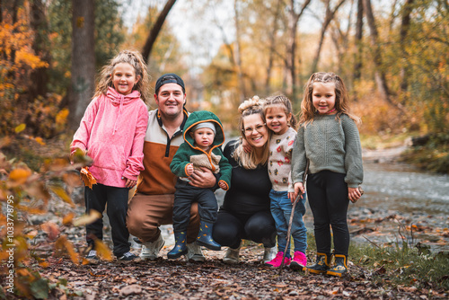 Joyful family in autumn season enjoy nature outdoors at autumn park.