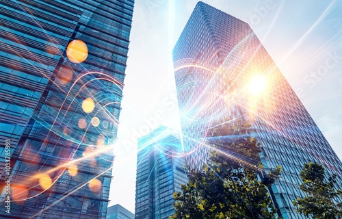 Tall glass buildings with a vibrant blue sky and lens flares.