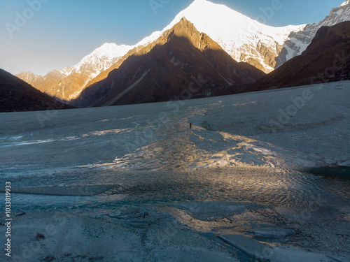 A tranquil icy landscape with surrounding mountains and a clear sky. photo