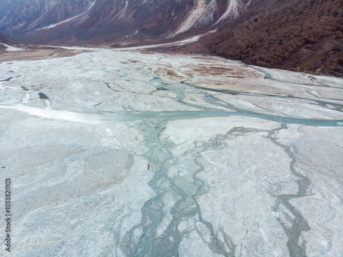 A breathtaking aerial view of a vast glacial valley surrounded by rugged mountains.