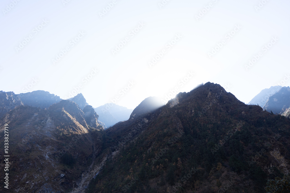 A stunning view of sunlit mountains during a bright, clear day. A stunning view of sunlit mountains during a bright, clear day.