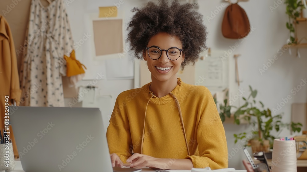 A woman with curly hair smiles while working on a laptop in a cozy, well-decorated workspace filled with plants and creative materials A woman with curly hair smiles while working on a laptop in a cozy, well-decorated workspace filled with plants and creative materials