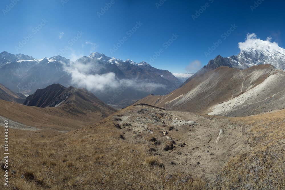 A breathtaking view of a mountainous landscape with clear blue skies and rugged peaks in the distance. A breathtaking view of a mountainous landscape with clear blue skies and rugged peaks in the distance.