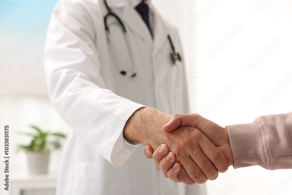 Doctor shaking hands with patient in hospital, closeup Doctor shaking hands with patient in hospital, closeup
