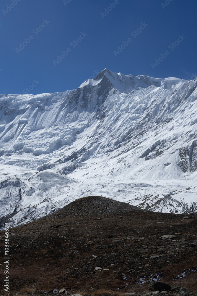 Fototapeta premium A stunning view of a snow-covered mountain peak under a clear blue sky.