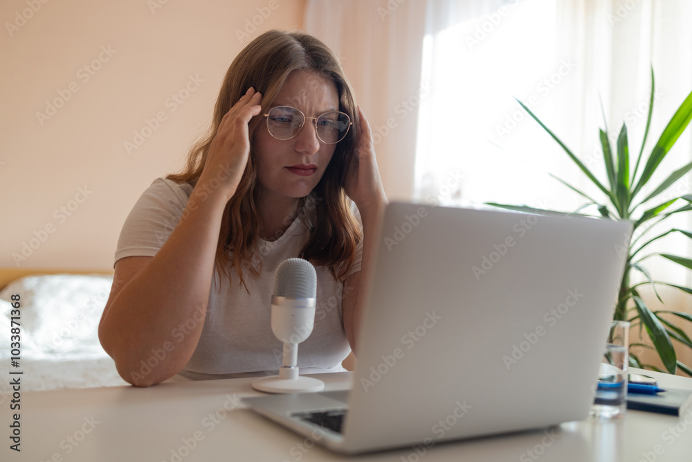 Worried fatigued mature business woman having headache at work. Tired busy 30s aged businesswoman feeling stress at home workplace looking at laptop computer in office. High quality photo