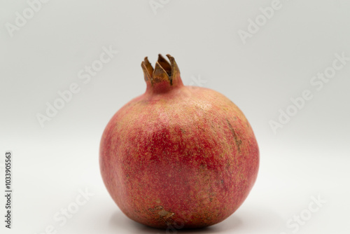 Close up of ripe red pomegranate on a white simple background  photo